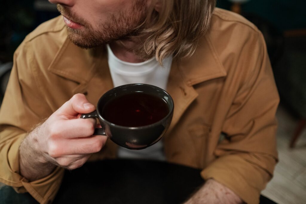 a man drinking tea with CBD oil
